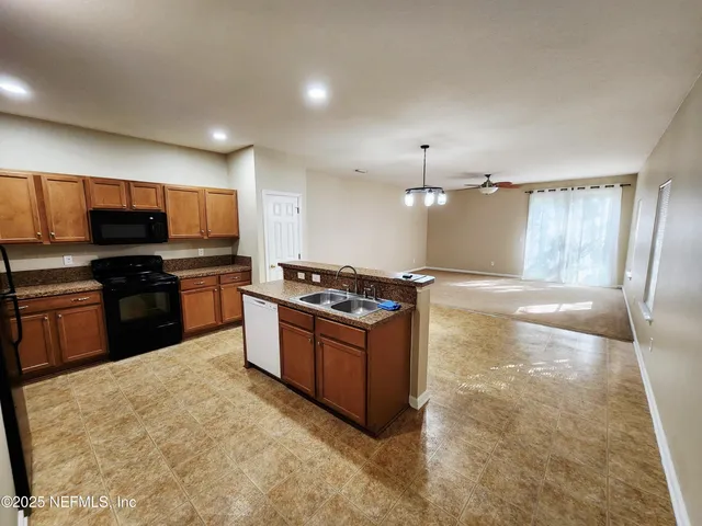 a large kitchen with a stove and a refrigerator