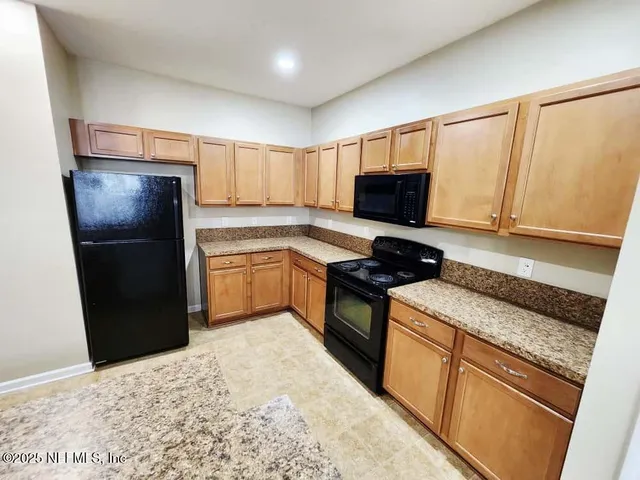 a kitchen with a refrigerator stove and microwave