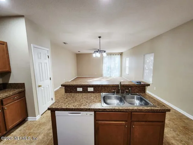 a kitchen with granite countertop a stove and a shower