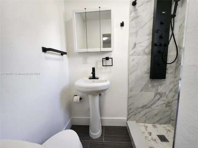 a bathroom with a sink toilet and shower