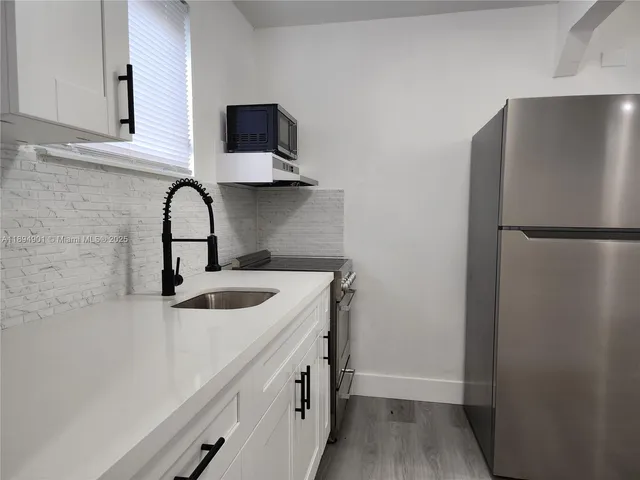 a kitchen with a refrigerator and a sink