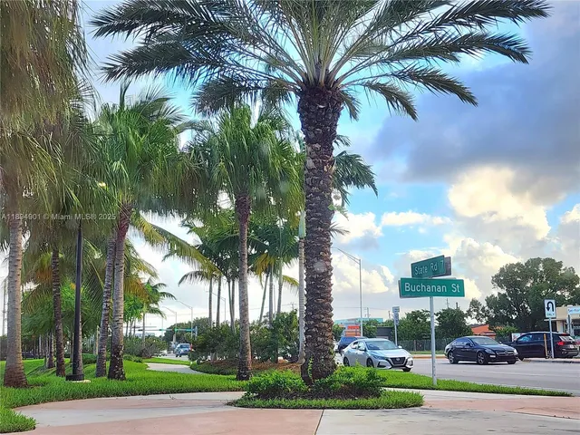 a view of a street with palm trees