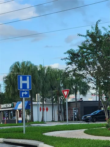 a front view of a house with a yard and a large tree