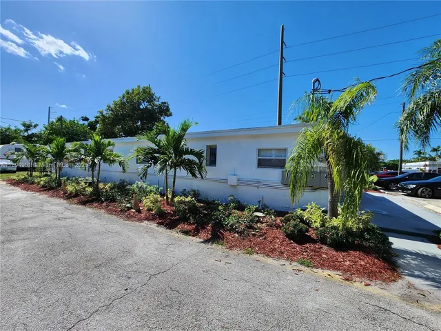 a palm plant sitting in front of a house