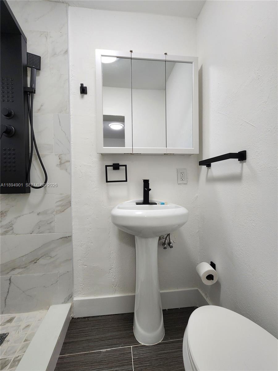 5934 Buchanan Street, Unit 4 Hollywood, FL 33021 - Photo 7 of 8 a bathroom with a sink a toilet and shower