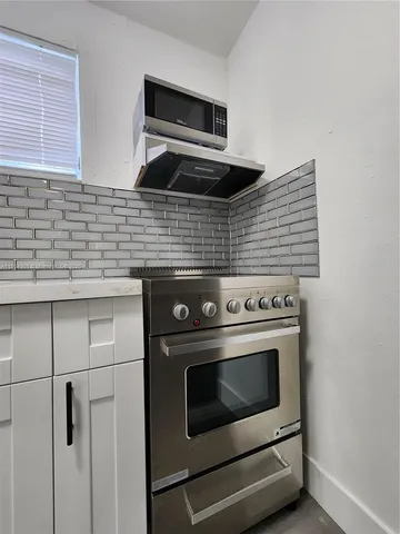 a stove top oven sitting inside of a kitchen