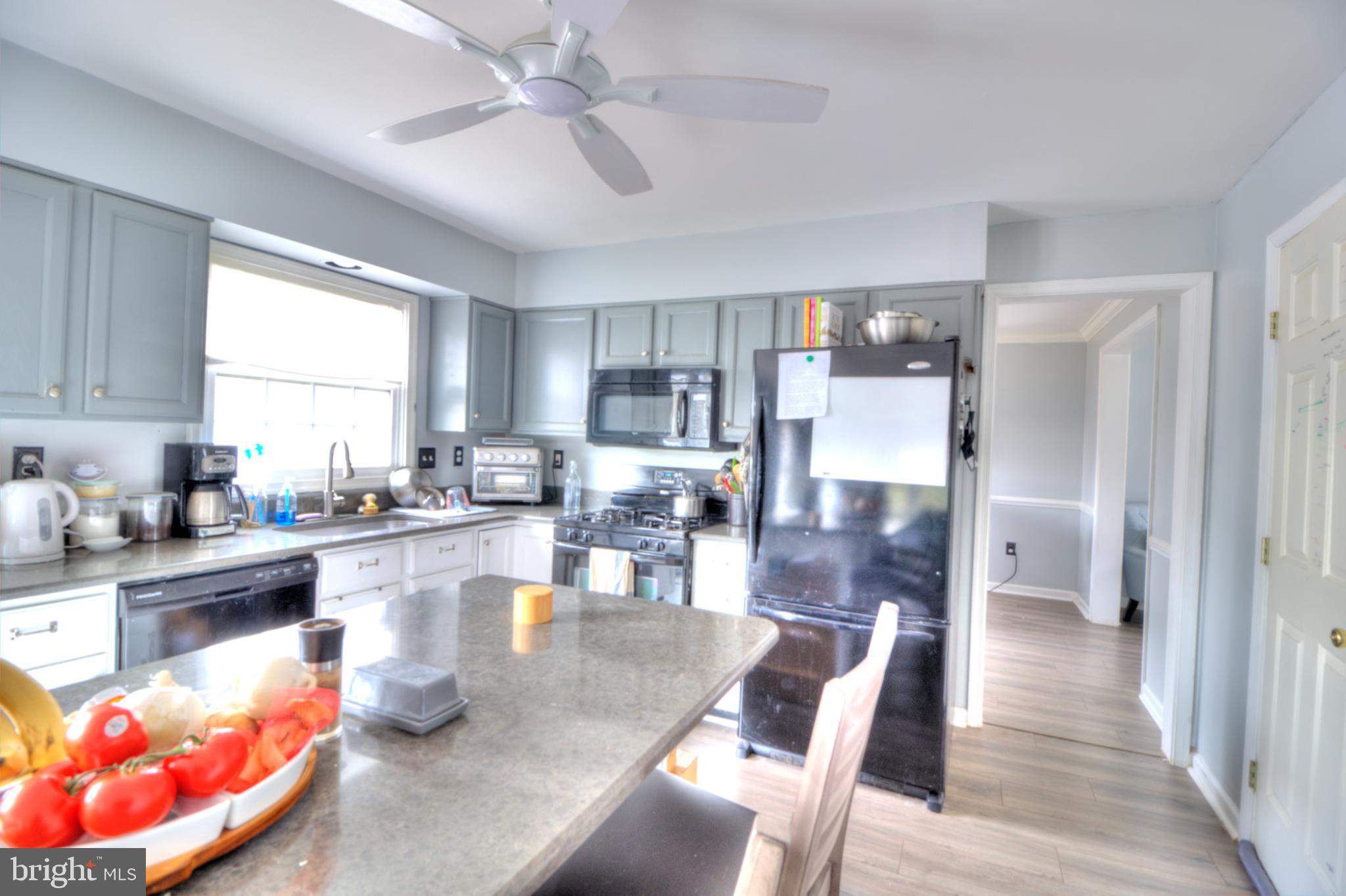 3879 Schroeder Avenue Perry Hall, MD 21128 - Photo 13 of 31 a dining hall with stainless steel appliances granite countertop a stove top oven a dining table and chairs with wooden floor