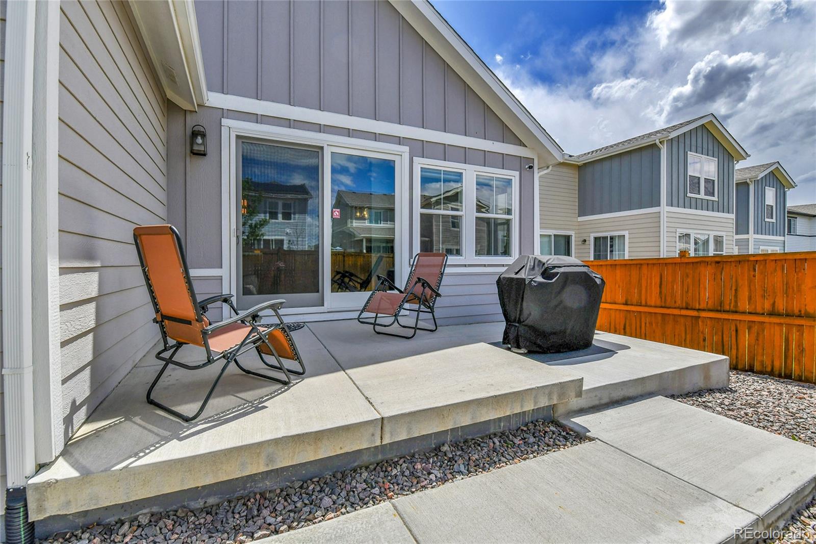 a view of a patio with table and chairs and wooden fence