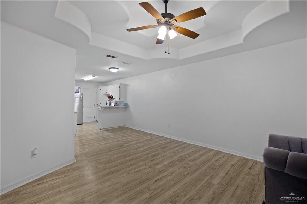 159 North Bridge Avenue Weslaco, TX 78596 - Photo 3 of 19 an empty room with wooden floor and windows