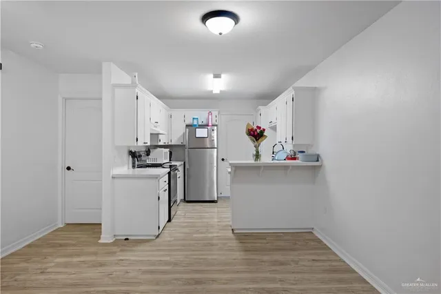 a view of kitchen with cabinets and wooden floor
