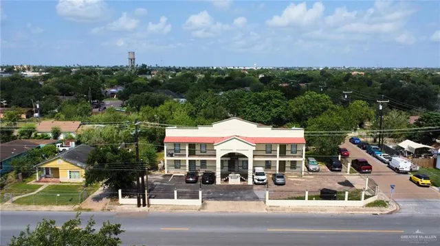 an aerial view of a house with yard lake and trees all around