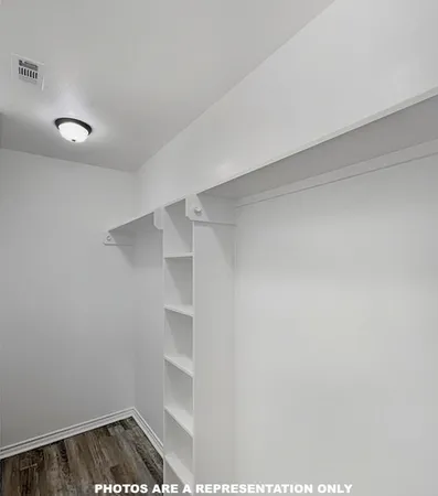 a view of walk in closet with empty racks
