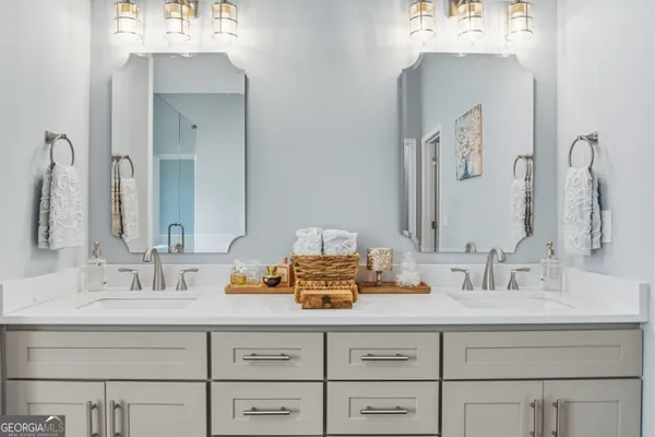 a bathroom with double vanity sinks and a mirror