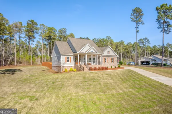 a front view of a house with a yard and trees