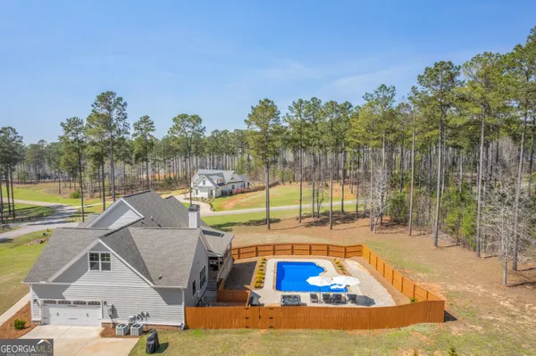 a view of a swimming pool with a patio and a yard