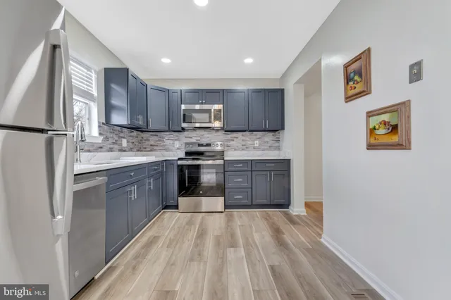 a kitchen with stainless steel appliances granite countertop a stove cabinets and a refrigerator