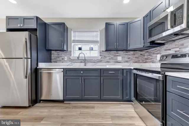 a kitchen with stainless steel appliances granite countertop a refrigerator sink and cabinets