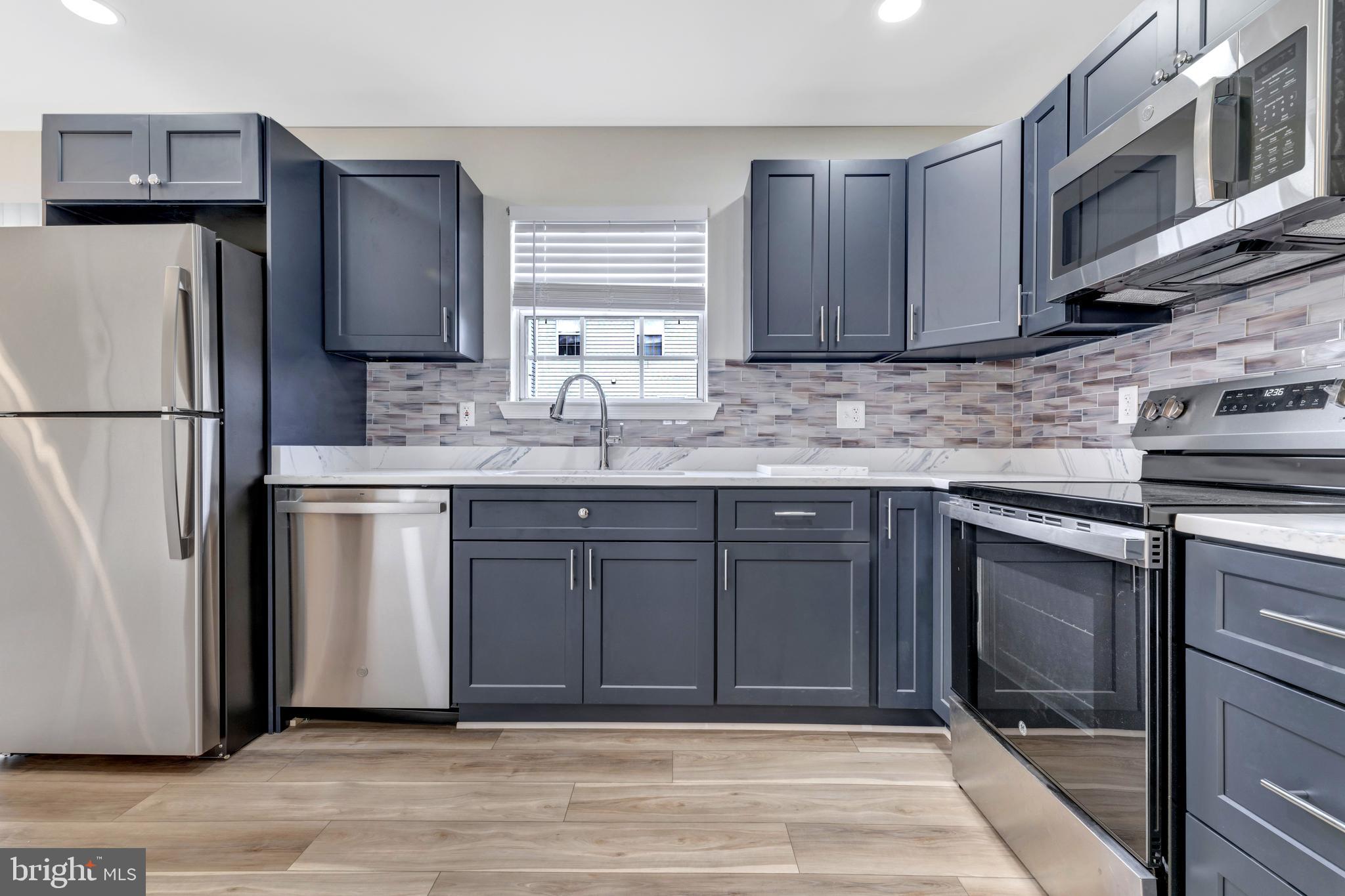 7108 Ruthgreen Road Windsor Mill, MD 21244 - Photo 14 of 25 a kitchen with stainless steel appliances granite countertop a refrigerator sink and cabinets