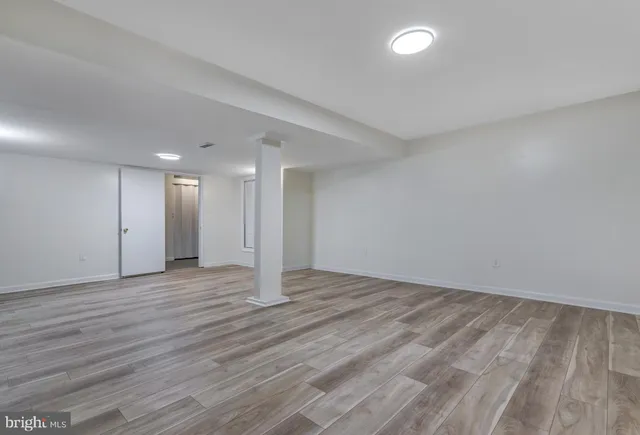 a view of an empty room with wooden floor