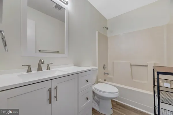 a bathroom with a toilet sink a mirror and shower