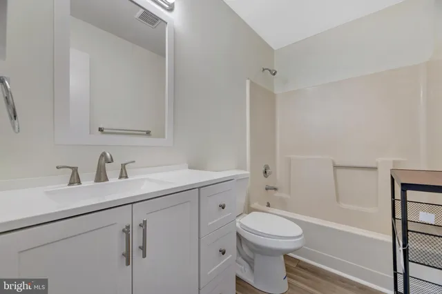 a bathroom with a toilet sink a mirror and shower