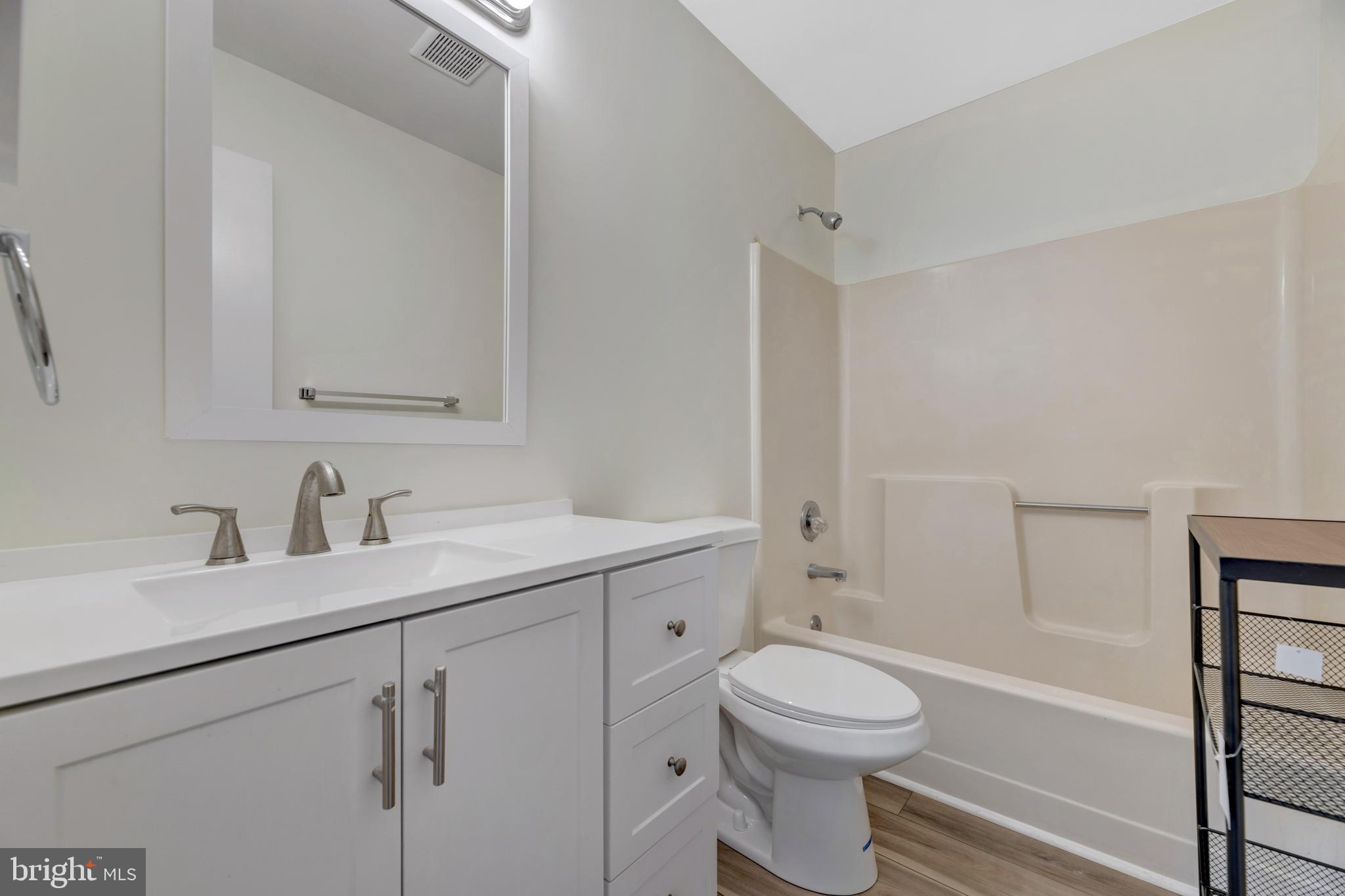 7108 Ruthgreen Road Windsor Mill, MD 21244 - Photo 6 of 25 a bathroom with a toilet sink a mirror and shower