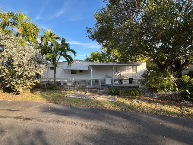 a view of a house with a yard and large tree