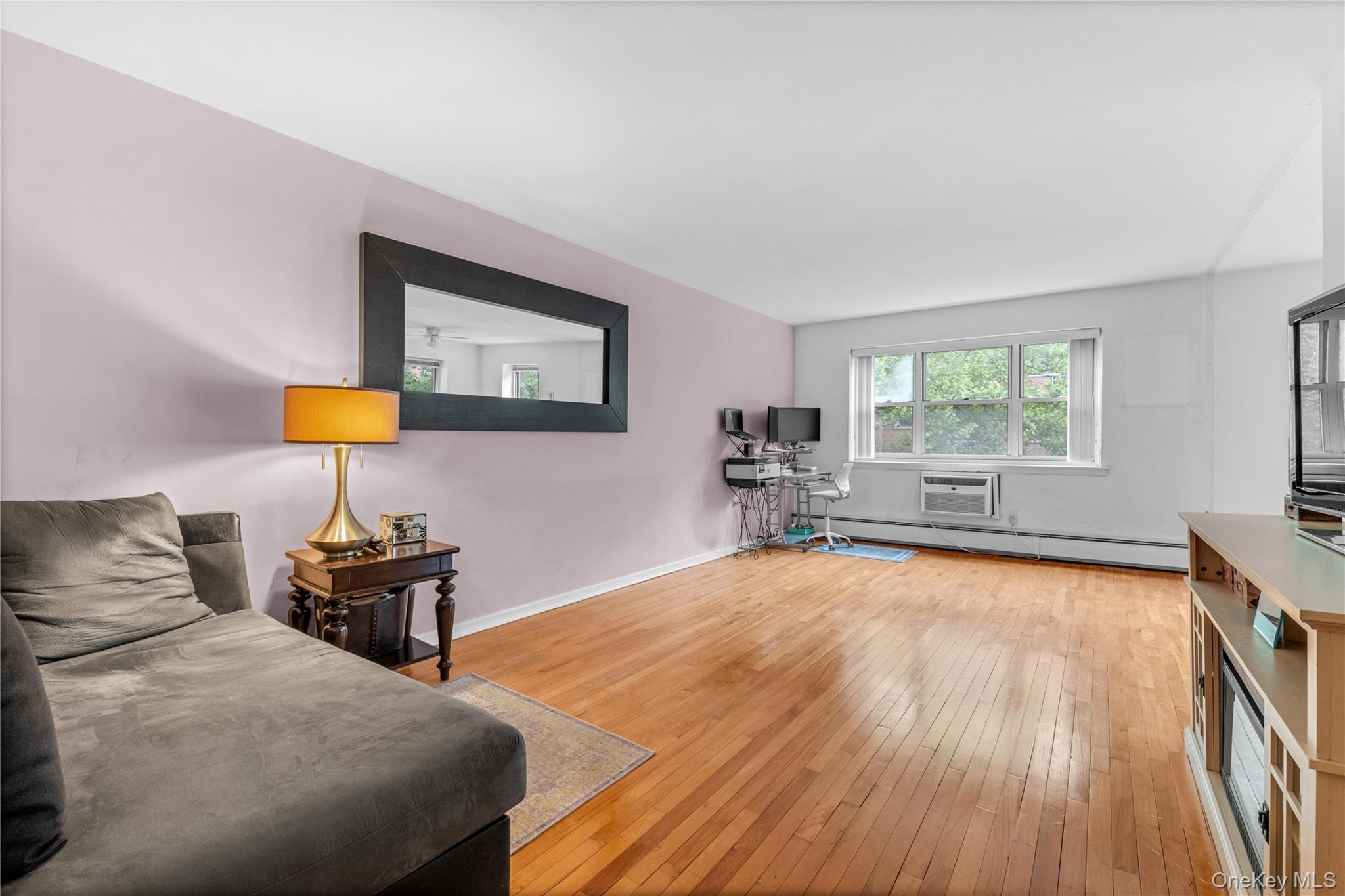 99-10 60th Avenue, Unit 3B Queens, NY 11368 - Photo 8 of 27 a bedroom with a bed and wooden floor