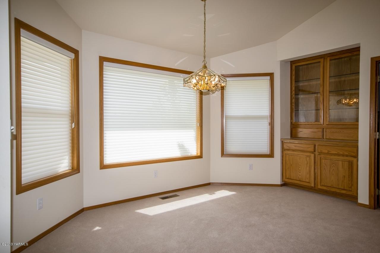 11814 Marble Road Yakima, WA 98908 - Photo 8 of 15 an empty room with chandelier fan and windows