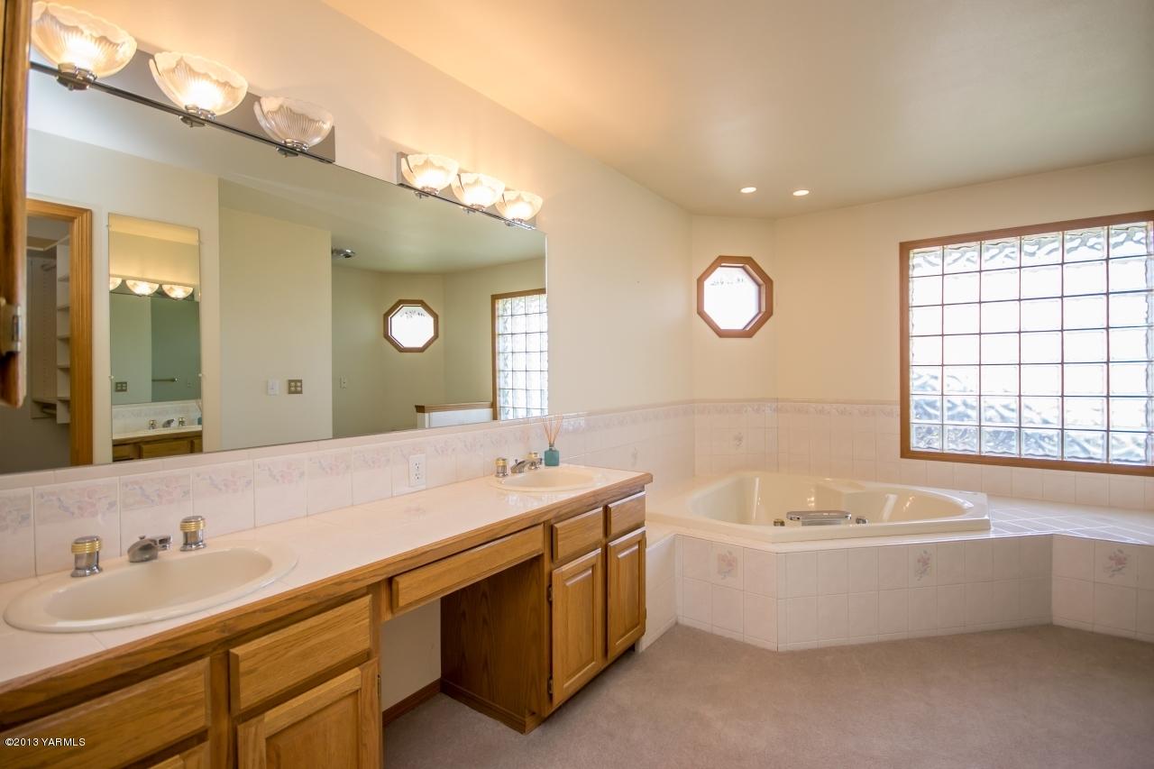 11814 Marble Road Yakima, WA 98908 - Photo 10 of 15 a bathroom with a tub double sink mirror and a bathtub