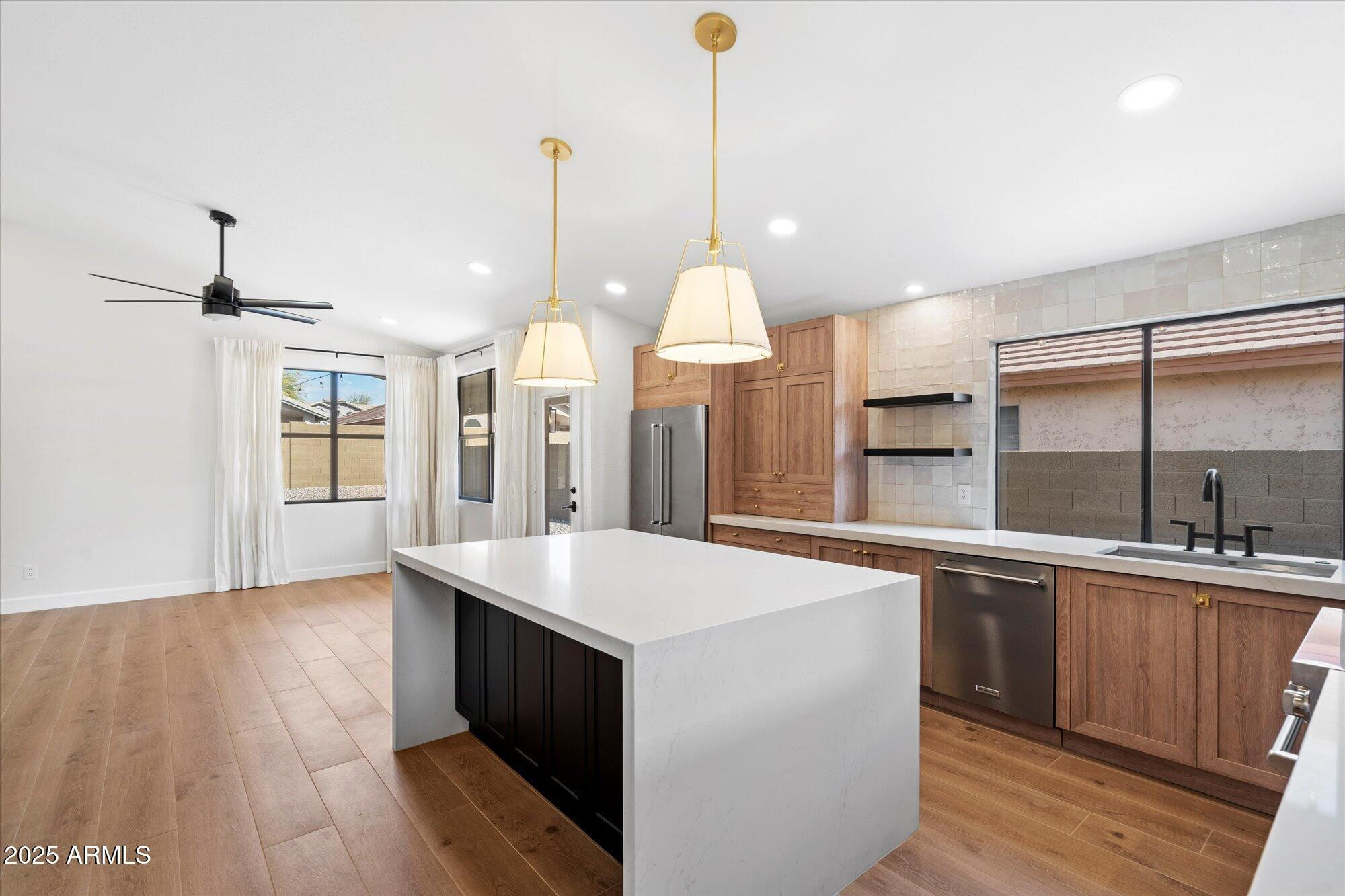 4706 East Jaeger Road Phoenix, AZ 85050 - Photo 12 of 30 a large kitchen with kitchen island a stove a sink a center island and wooden floor