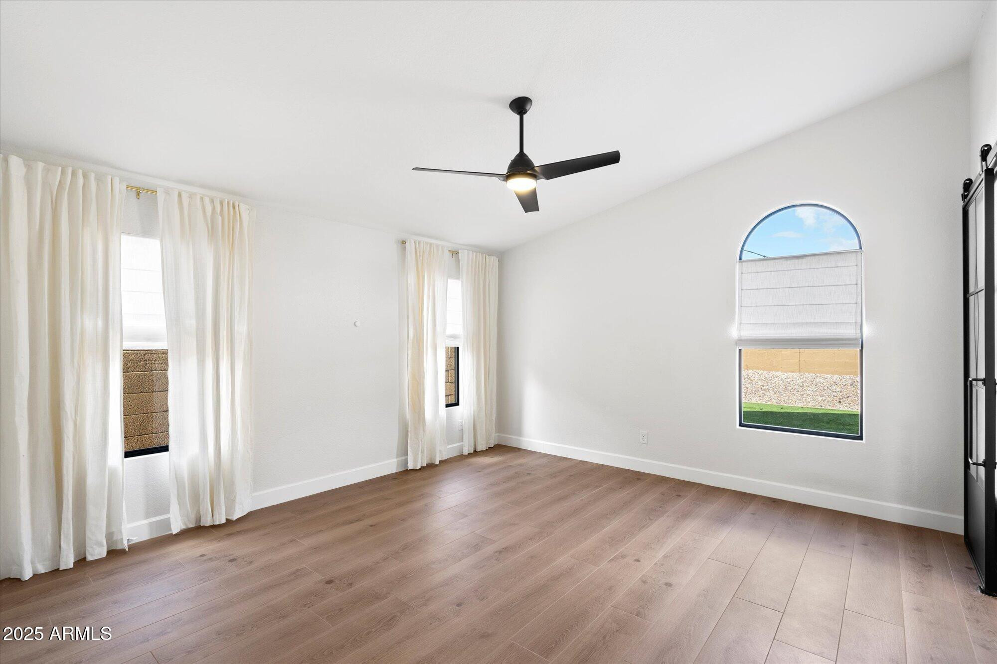 4706 East Jaeger Road Phoenix, AZ 85050 - Photo 17 of 30 a view of empty room with wooden floor and fan