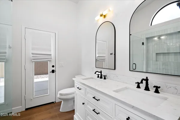a bathroom with a double vanity sink toilet and a mirror