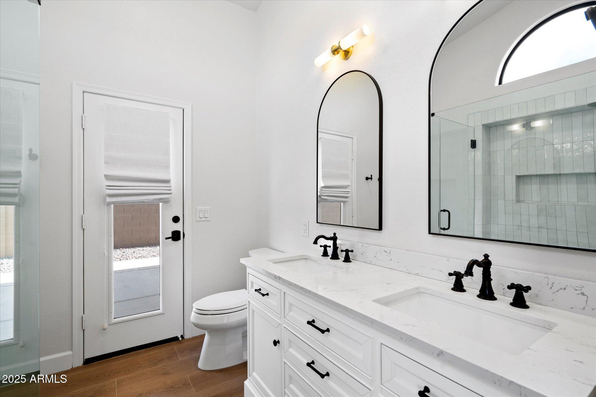 4706 East Jaeger Road Phoenix, AZ 85050 - Photo 20 of 30 a bathroom with a double vanity sink toilet and a mirror