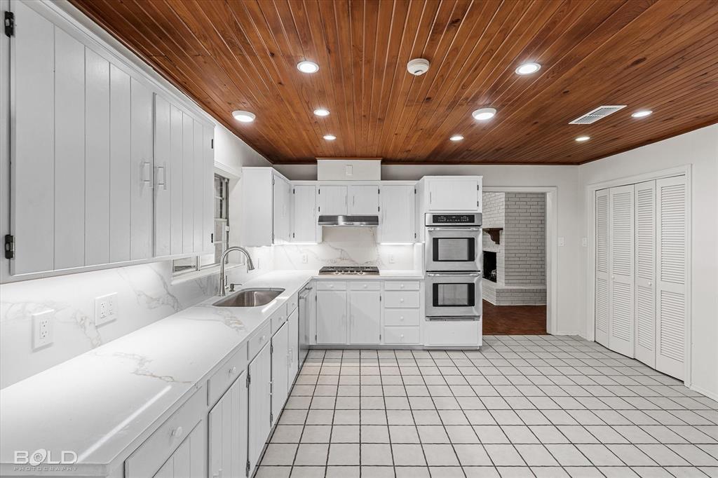 5800 Jefferson Paige Road Shreveport, LA 71119 - Photo 17 of 39 a large white kitchen with stainless steel appliances granite countertop a sink and cabinets
