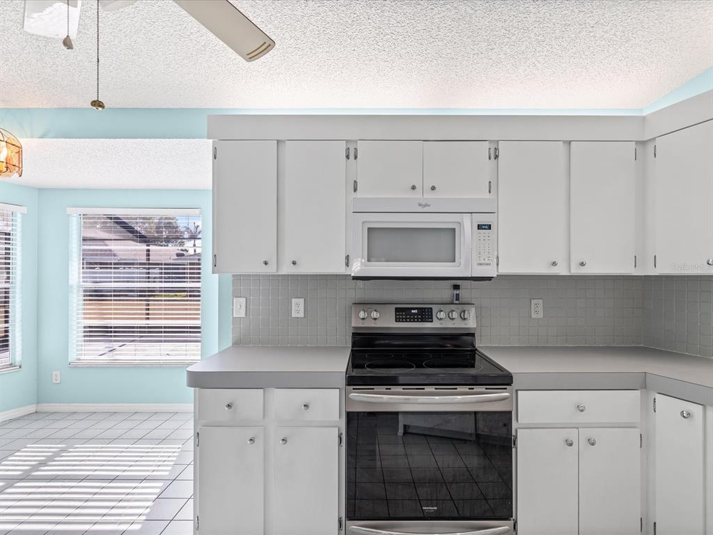 5853 Redhawk Drive New Port Richey, FL 34655 - Photo 13 of 38 a kitchen with white cabinets and a stove