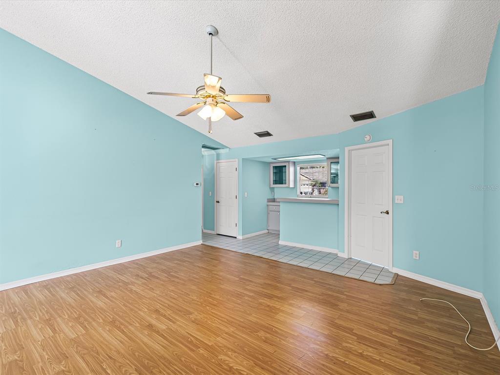 5853 Redhawk Drive New Port Richey, FL 34655 - Photo 23 of 38 a view of a big room with wooden floor and a ceiling fan