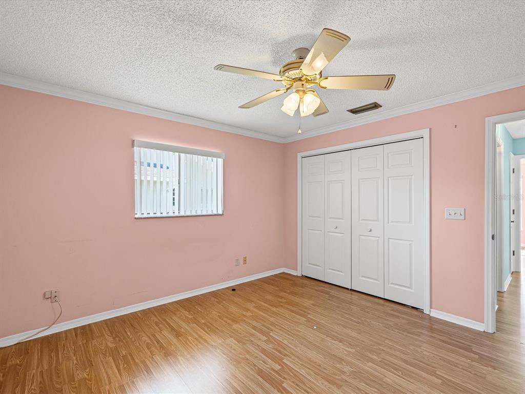 5853 Redhawk Drive New Port Richey, FL 34655 - Photo 36 of 38 an empty room with wooden floor fan and windows