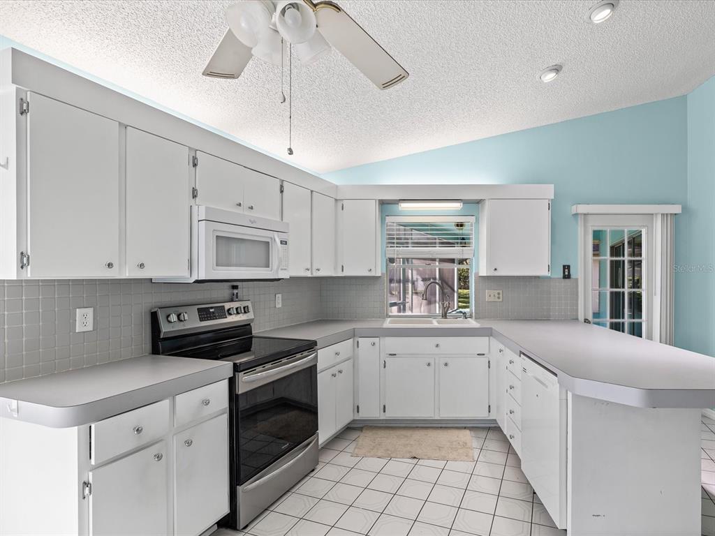 5853 Redhawk Drive New Port Richey, FL 34655 - Photo 9 of 38 a kitchen with a sink window and cabinets