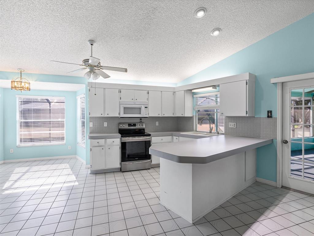 5853 Redhawk Drive New Port Richey, FL 34655 - Photo 10 of 38 a kitchen with a sink stove and cabinets