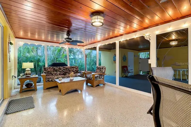 a living room with patio furniture and a chandelier