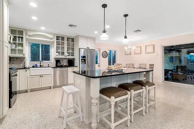 a kitchen with kitchen island granite countertop a sink a center island stainless steel appliances and cabinets