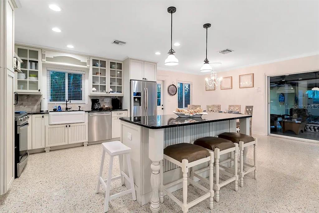 2795 North Beach Road, Unit A Englewood, FL 34223 - Photo 18 of 53 a kitchen with kitchen island granite countertop a sink a center island stainless steel appliances and cabinets