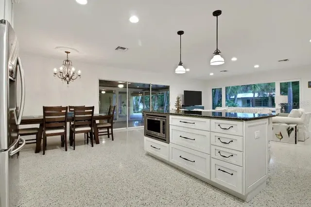 a kitchen with stainless steel appliances kitchen island granite countertop a table and chairs in it