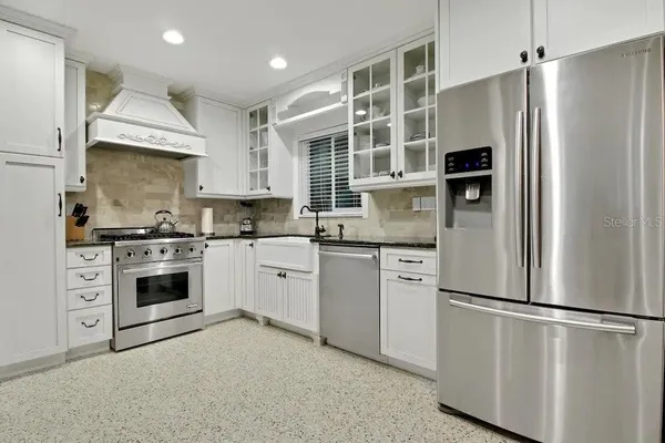 a kitchen with stainless steel appliances a refrigerator sink and cabinets