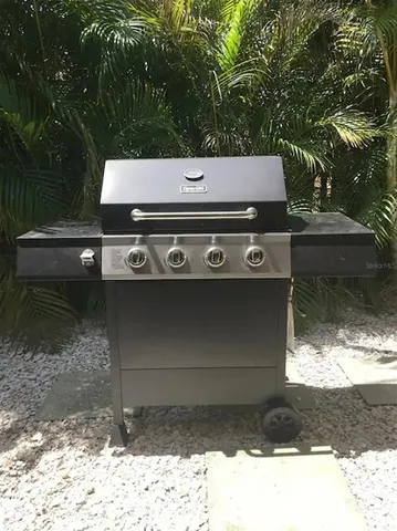 a view of a fountain in the yard with wooden fence
