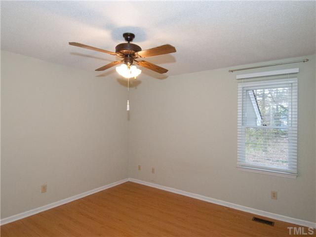 3629 Castlegate Drive Raleigh, NC 27616 - Photo 6 of 9 a view of a small space with wooden floor a chandelier fan and windows