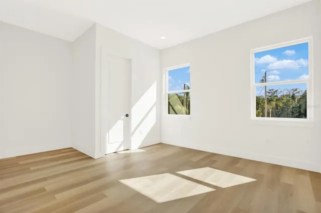 an empty room with wooden floor and window