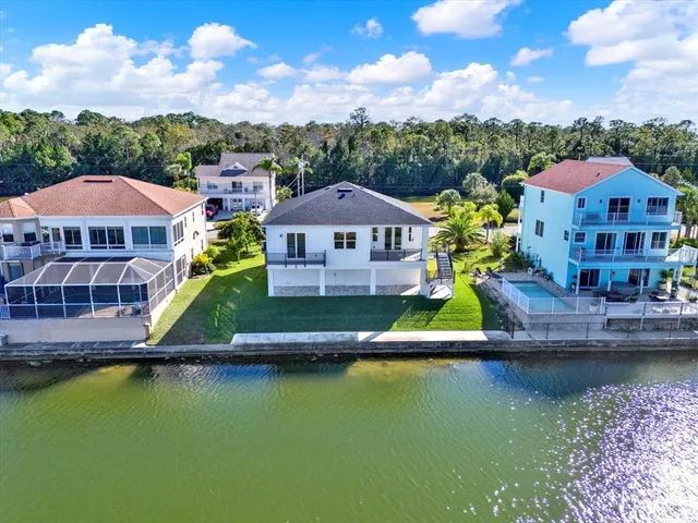 an aerial view of a house with a garden and lake view