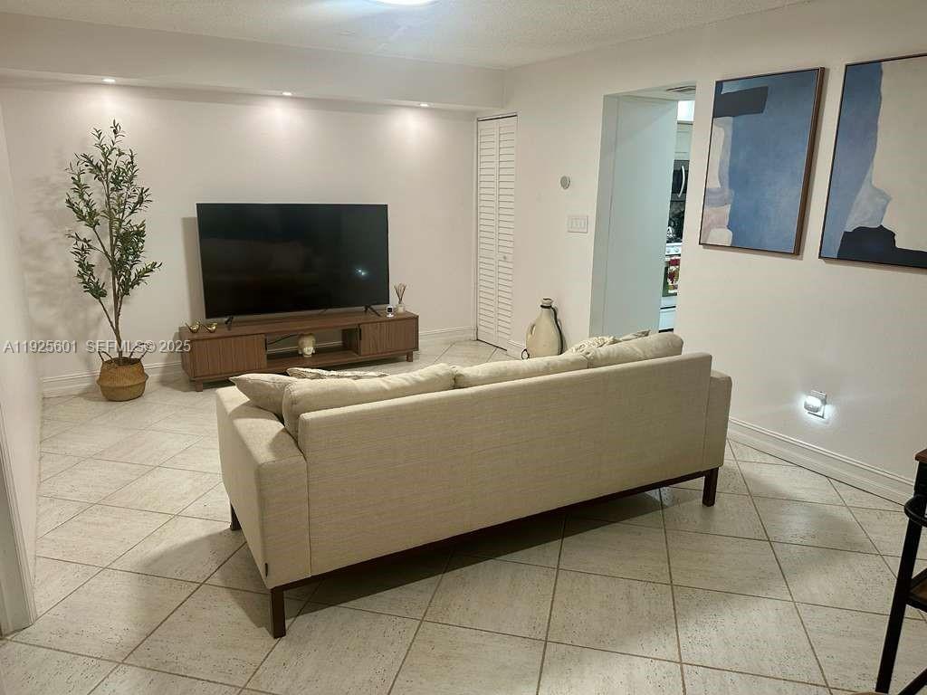 7100 Southwest 112th Place Miami, FL 33173 - Photo 6 of 21 a living room with furniture and a flat screen tv